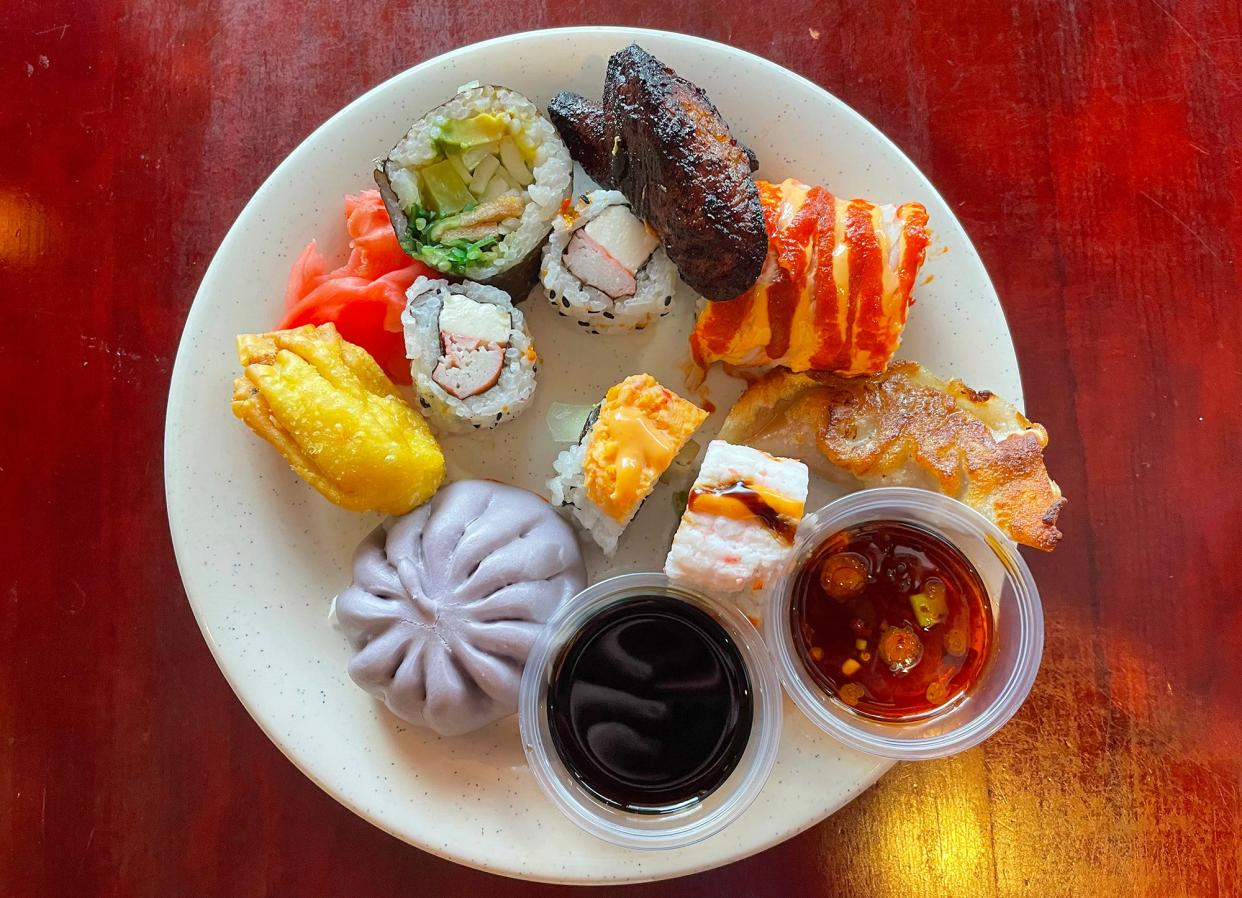 A plate of assorted sushi, fried banana, crab rangoon, dumplings, sauces and steamed ube bun from Hibachi Grill Supreme Buffet in Athens, Ga. on Thursday, July 6, 2023.