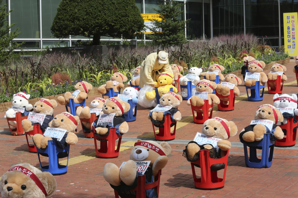 A street vendor places a teddy bear to protest against a crackdown on illegal street vendors, in front of the Mapo ward office in Seoul, South Korea, Thursday, Sept. 24, 2020. Street vendors replaced protestors with teddy bears to avoid the violation of an ongoing ban on rallies with more than 10 people amid the coronavirus pandemic. The signs read: "Stop crackdown." (AP Photo/Ahn Young-joon)