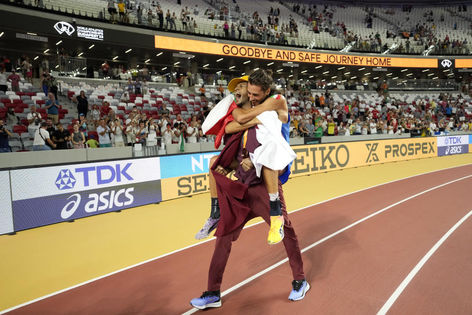 Bronze medalist Mutaz Essa Barshim, of Qatar, carries gold medalist Gianmarco Tamberi, of Italy, celebrating after the Men's high jump final during the World Athletics Championships in Budapest, Hungary, Tuesday, Aug. 22, 2023. (AP Photo/Ashley Landis)