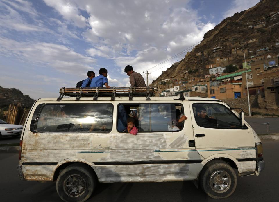 People travel in an overcrowded van in Kabul