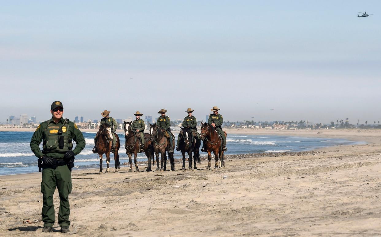 US customs and border protection agents stand guard near the US-Mexico border fence: AFP/Getty Images