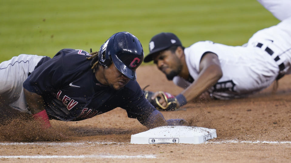 Cleveland Indians' Jose Ramirez, left, dives to first base to beat the tag of Detroit Tigers first baseman Jeimer Candelario during the seventh inning of a baseball game in Detroit, Saturday, Aug. 15, 2020. (AP Photo/Paul Sancya)