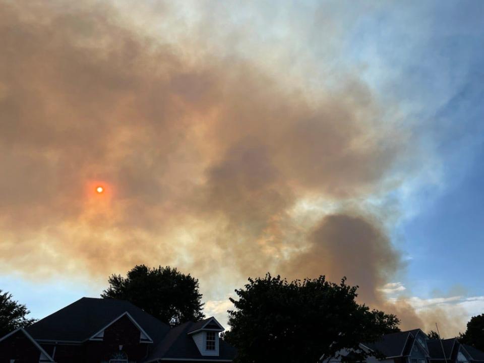 Smoke pours over a Greenwood, Arkansas neighborhood Tuesday night as residents evacuate.