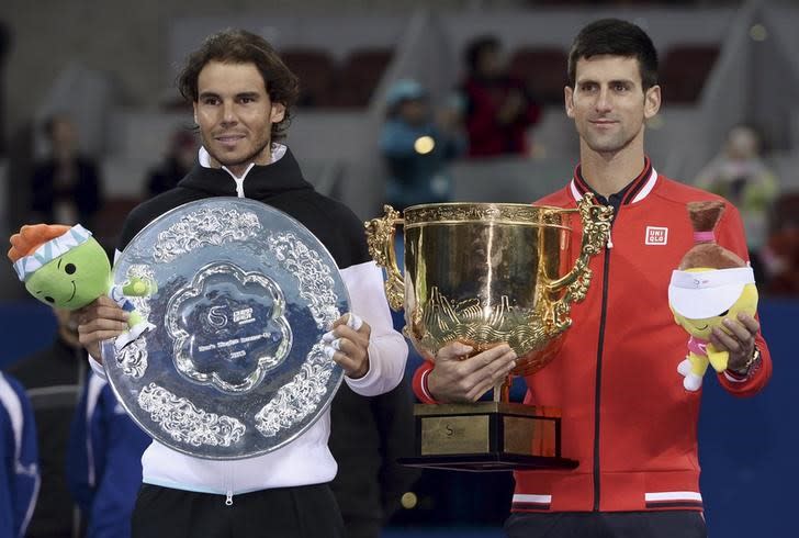 IMAGEN DE ARCHIVO. El campeón Novak Djokovic y el finalista Rafael Nadal posan con los trofeos tras la final del torneo China Open en Pekín