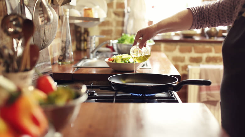 pouring oil into skillet