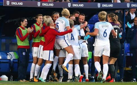 Nikita Parris and England teammates celebrate with Mark Sampson after scoring the opening goal during the FIFA Women's World Cup Qualifier between England and Russia on Tuesday - Credit: Alex Livesey/Getty Images