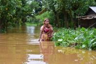 NAGAON,INDIA-JULY 22,2020 :A Woman wade through a flooded street at a flood affected area in Nagaon District of Assam ,India- PHOTOGRAPH BY Anuwar Ali Hazarika / Barcroft Studios / Future Publishing (Photo credit should read Anuwar Ali Hazarika/Barcroft Media via Getty Images)