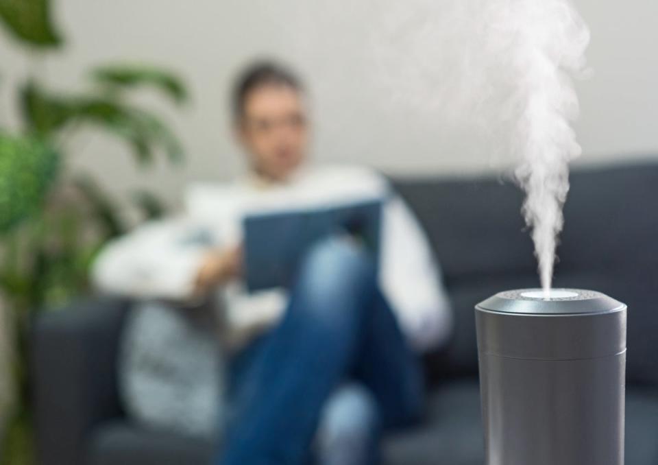 Dehumidifier on with person on couch blurred in background