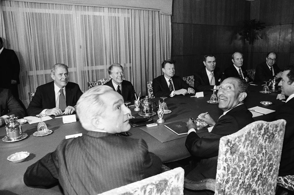 <p>Egypt’s President Anwar Sadat and Prime Minister Mustafa Khalil, foreground, look back at the photographers as the U.S. delegation looks on across the table during a meeting in Alexandria Friday, March 9, 1979. The U.S. delegation, from left, Secretary of State Cyrus Vance, President Jimmy Carter, National Security Advisor Zbigniew Brzezinski, Ambassador Hermann Eilts and Ambassador at large Alfred Atherton. (Photo: AP) </p>