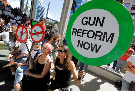 FILE PHOTO: Protesters hold signs as they call for a reform of gun laws three days after the shooting at Marjory Stoneman Douglas High School, at a rally in Fort Lauderdale, Florida, U.S., February 17, 2018. REUTERS/Jonathan Drake/File Photo