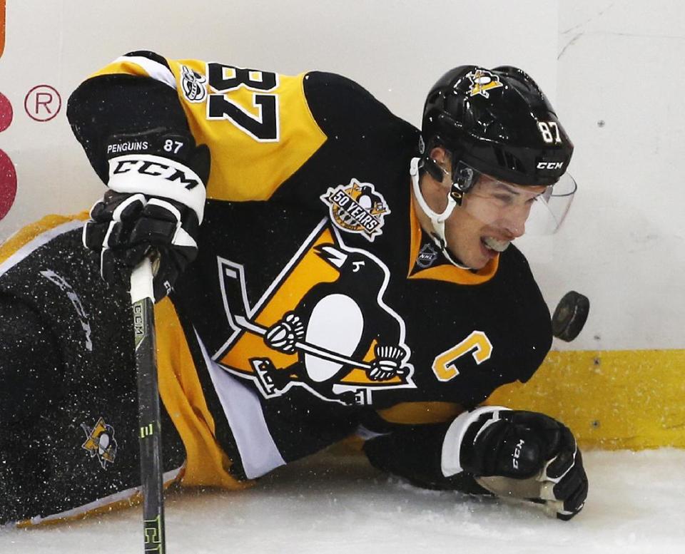 Pittsburgh Penguins' Sidney Crosby falls to the ice as the puck bounces in front of him in the first period of an NHL hockey game against the Washington Capitals in Pittsburgh, Monday, Jan. 16, 2017. (AP Photo/Gene J. Puskar)