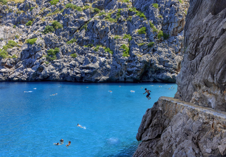 Tourists, pictured here cliff diving in Mallorca.