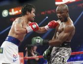 Manny Pacquiao, left, of the Philippines, throws a left at Timothy Bradley during the WBO welterweight title boxing bout Saturday, April 12, 2014, in Las Vegas. (AP Photo/Eric Jamison)