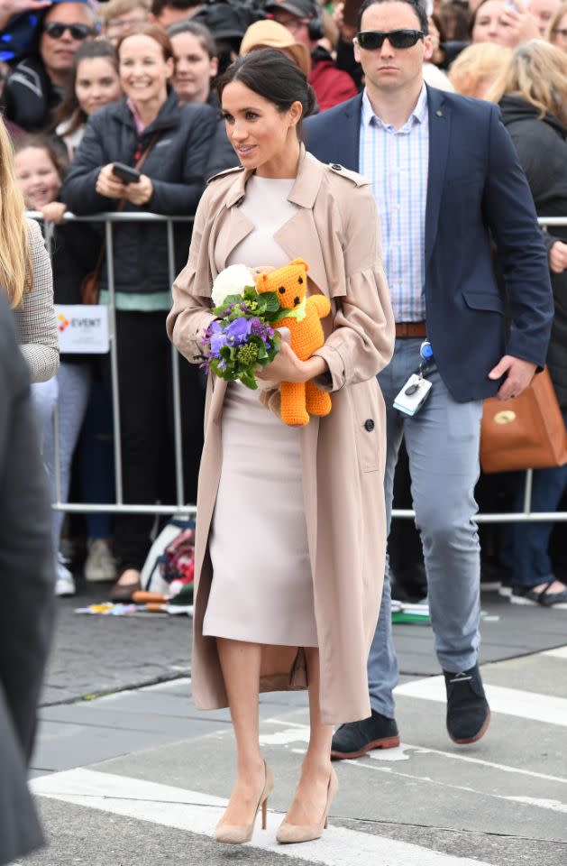 Meghan verzauberte in einem maßgeschneiderten cremefarbenen Brandon Maxwell Midi-Shift-Kleid und einem Burberry Bishop Trenchcoat darüber. Bild: Getty