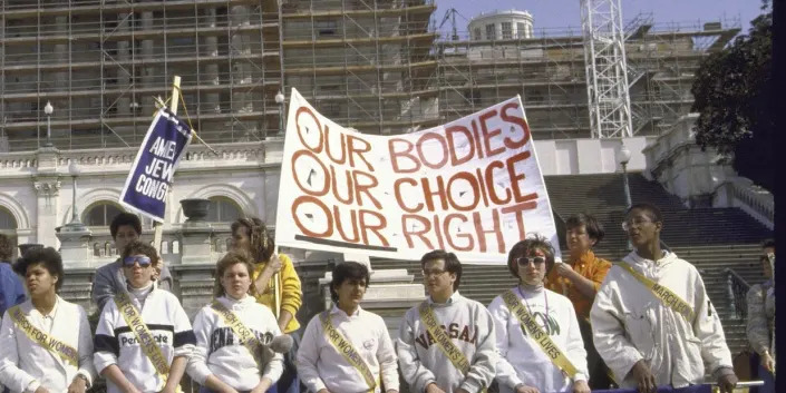 NOW members during apro-abortion demonstration on March 1, 1986. One sign reads: Our bodies, our choice, our right.