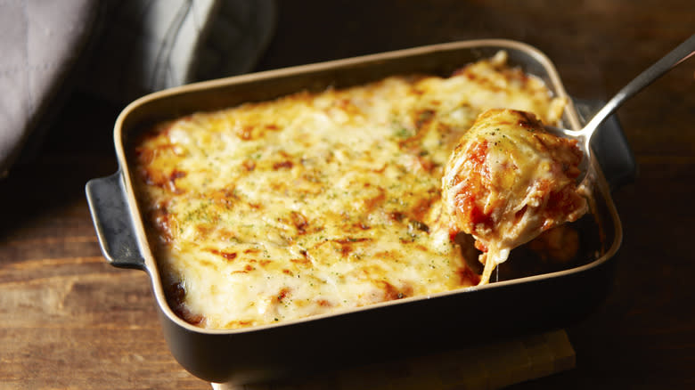 Pulling cheesy lasagna ceramic pan