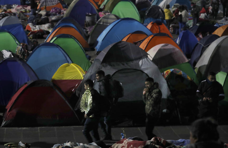 Gente pasa frente a un campamento de carpas camino de la Basílica de la Virgen de Guadalupe en Ciudad de México en la peregrinación anual, jueves 12 de diciembre de 2019. El coordinador de defensa civil, David León, estimó la concurrencia en 9,8 millones de personas, cifra superior a la población de la capital mexicana. (AP Foto/Marco Ugarte)