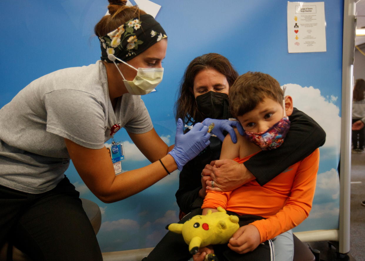 Five-year-old Renan Rojas sits on his mom Daniela Cantano's lap as he receives the Pfizer coronavirus vaccine from registered nurse Jillian at Rady's Children's Hospital in San Diego.