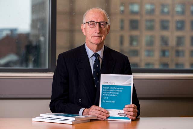 Sir John Gillen holds a copy of the Gillen Review Report