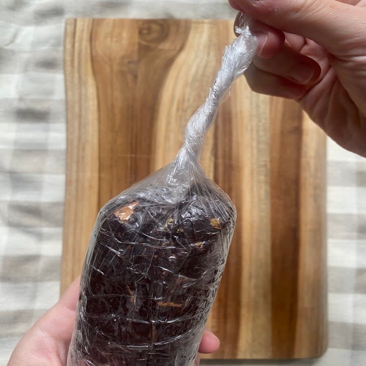 the plastic at the end of a wrapped chocolate salami being twisted