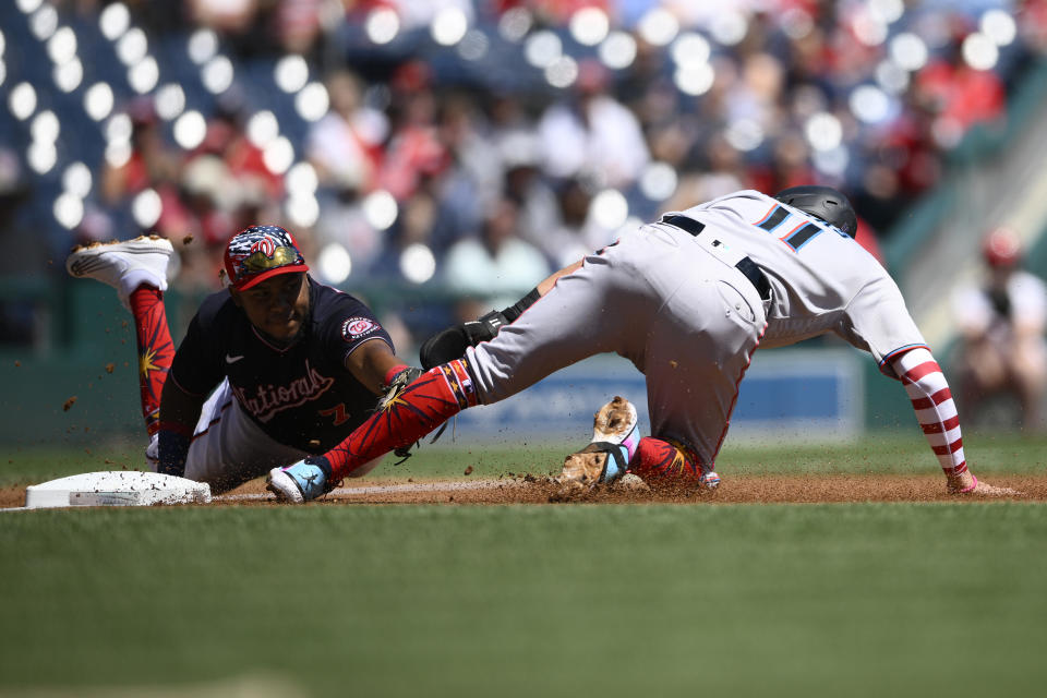 Miami Marlins' Miguel Rojas (11) is out at third by Washington Nationals third baseman Maikel Franco, left, on a single by Marlins' Brian Anderson during the first inning of a baseball game, Monday, July 4, 2022, in Washington. (AP Photo/Nick Wass)