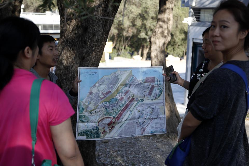 Tourists guides show a map of the Acropolis to tourists in Athens, Thursday, Oct. 11, 2018 during a 24-hour strike called by a Greek union representing staff at the country's ancient site. The union accused the Greek government of failing to list publicly-owned properties that have been transferred to a powerful privatization fund created during the country's international bailouts. (AP Photo/Thanassis Stavrakis)