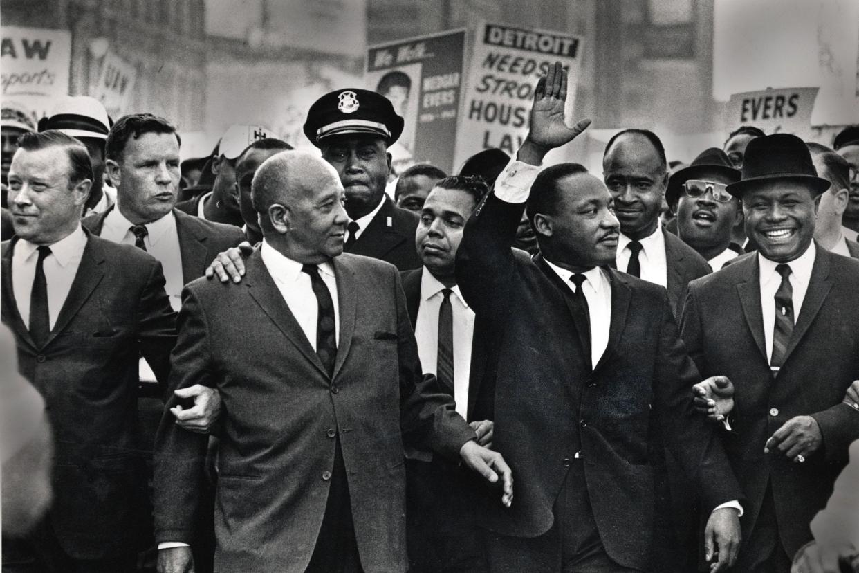 Martin Luther King Jr. waves to onlookers as he leads the 125,000-strong "Walk to Freedom" march down Woodward Avenue in Detroit in 1963. From left to right in the front row are Walter Reuther, Benjamin McFall, Cmdr. George Harge (a cop with cap), King, and the Rev. C.L. Franklin.
