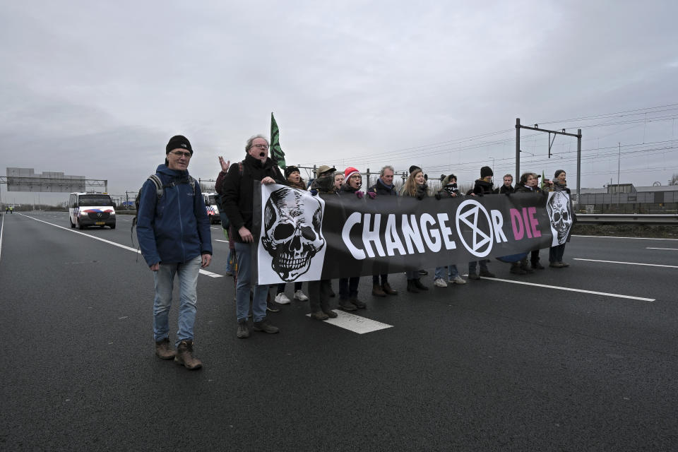 Climate activists block the main highway around Amsterdam near the former headquarters of a ING bank to protest its financing of fossil fuels, Saturday, Dec. 30, 2023. Protestors walked onto the road at midday, snarling traffic around the Dutch capital in the latest road blockade organized by the Dutch branch of Extinction Rebellion. (AP Photo/Patrick Post)