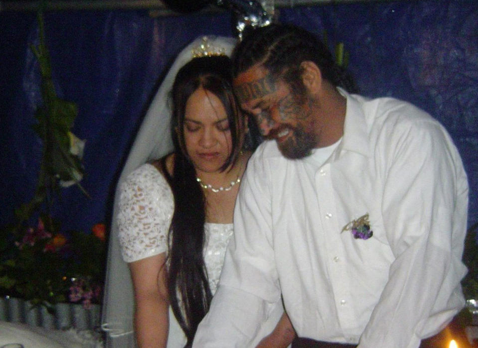 Berta Harrison-Ratima and her husband Malcolm Ratima. She's seen in a wedding dress and the couple are cutting a cake.