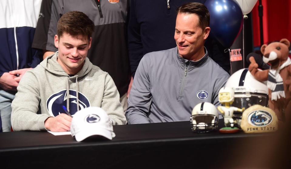 Central York senior quarterback Beau Pribula (left) signs his national letter of intent to play football for Penn State as his father, Tad, looks on Wednesday, Dec. 15, 2021 at Central York High School.