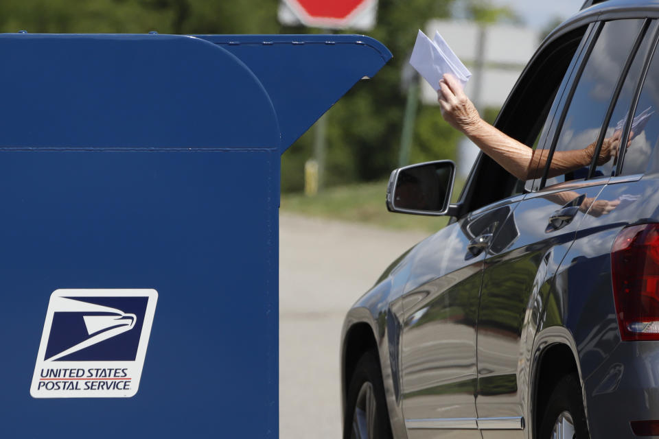 FILE - In this Aug. 19, 2020, file photo, a person deposits mail in a box outside United States Post Office in Cranberry Township, Pa. U.S. Postal Service records show delivery delays have persisted across the country as millions of Americans began voting by mail, raising the possibility of ballots being rejected because they arrive too late. Parts of the politically coveted battleground states of Wisconsin, Michigan, Pennsylvania and Ohio fell short of delivery goals by wide margins as the agency struggles to regain its footing after a tumultuous summer. (AP Photo/Gene J. Puskar, File)