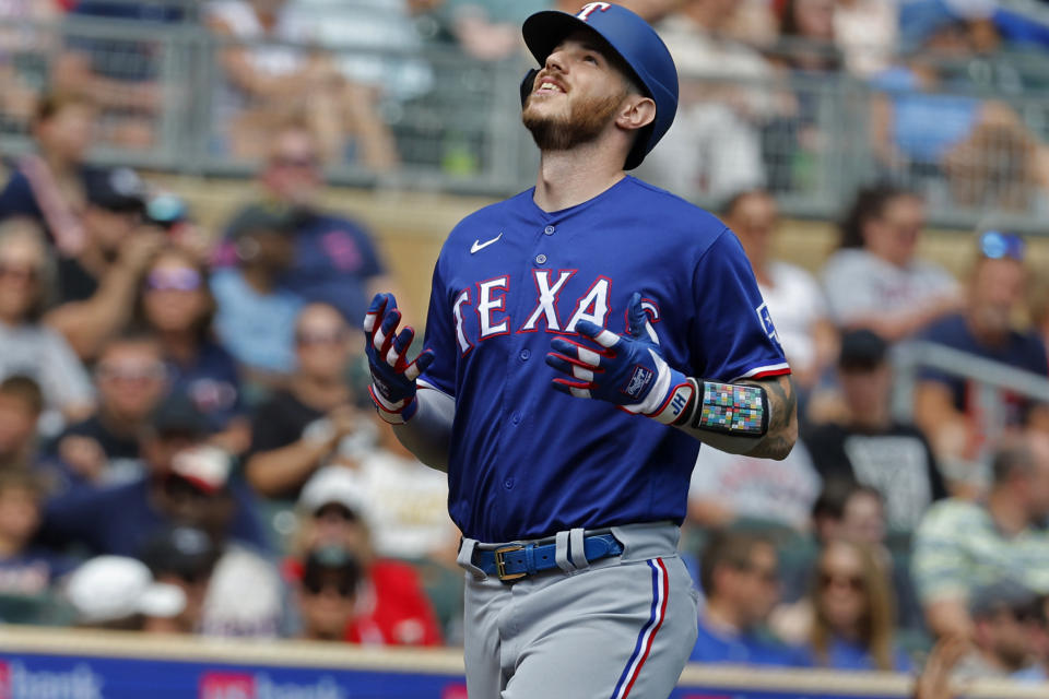 Texas Rangers' Jonah Heim looks to the sky as he scores on his grand slam against the Minnesota Twins in the fourth inning of a baseball game Sunday, Aug. 27, 2023, in Minneapolis. (AP Photo/Bruce Kluckhohn)