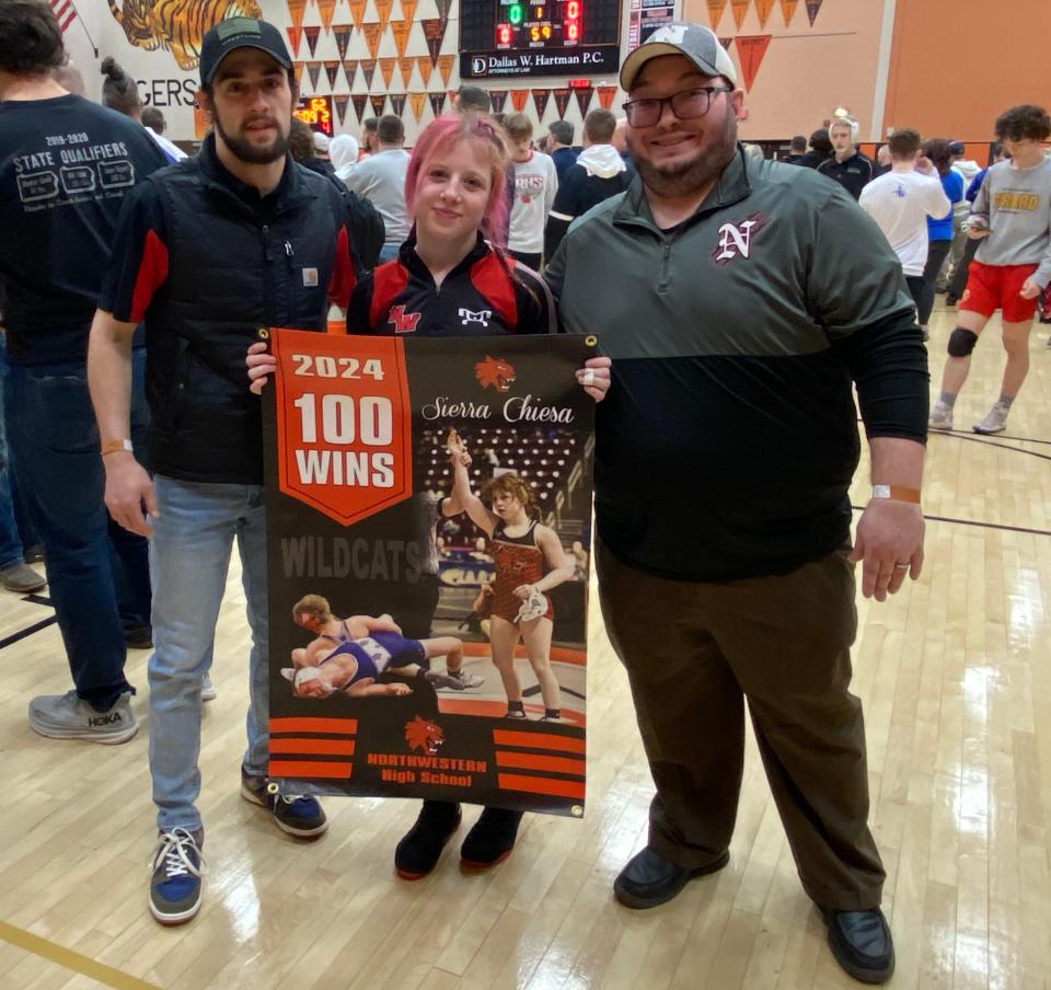 Sierra Chiesa and her Northwestern coaches celebrate the junior 107-pounder’s 100th career win Friday at Sharon High School. Chiesa is the first female in Pennsylvania high school wrestling history to reach 100 wins.