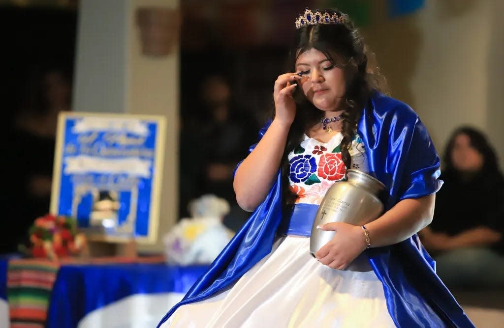 Karina wipes away tears as she dances to the song the song "Préstame a mi padre" with her father's ashes during the father-daughter dance.