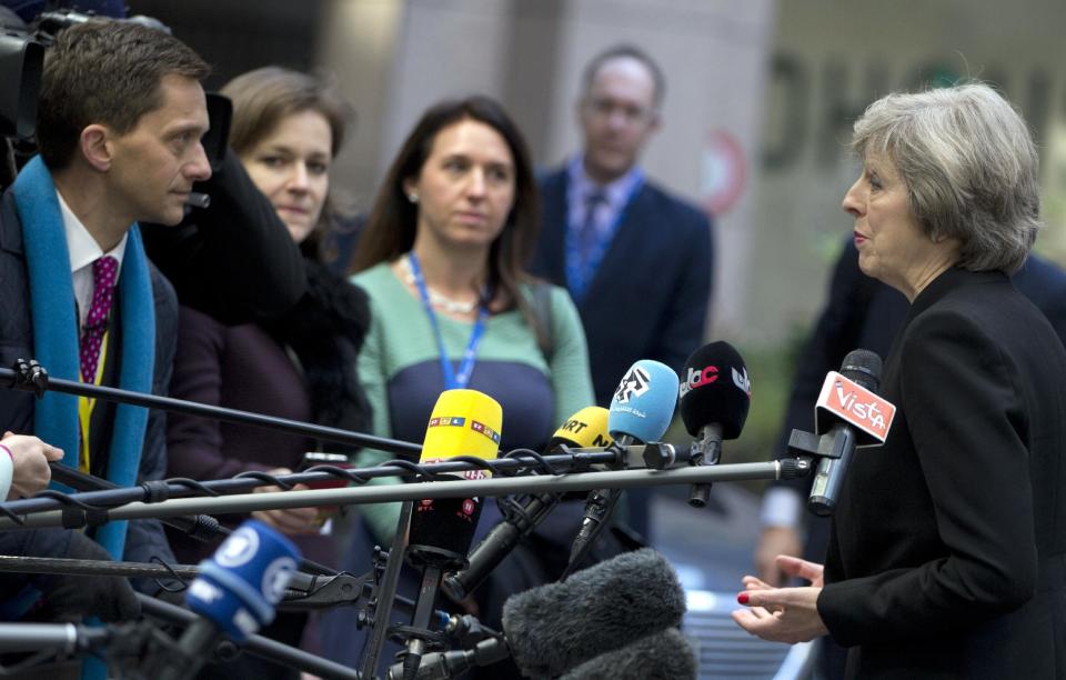 British Prime Minister Theresa May, right, speaks with the media as she arrives for an EU Summit in Brussels on Thursday, Dec. 15, 2016. European Union leaders meet Thursday in Brussels to discuss defense, migration, the conflict in Syria and Britain's plans to leave the bloc. (AP Photo/Virginia Mayo)
