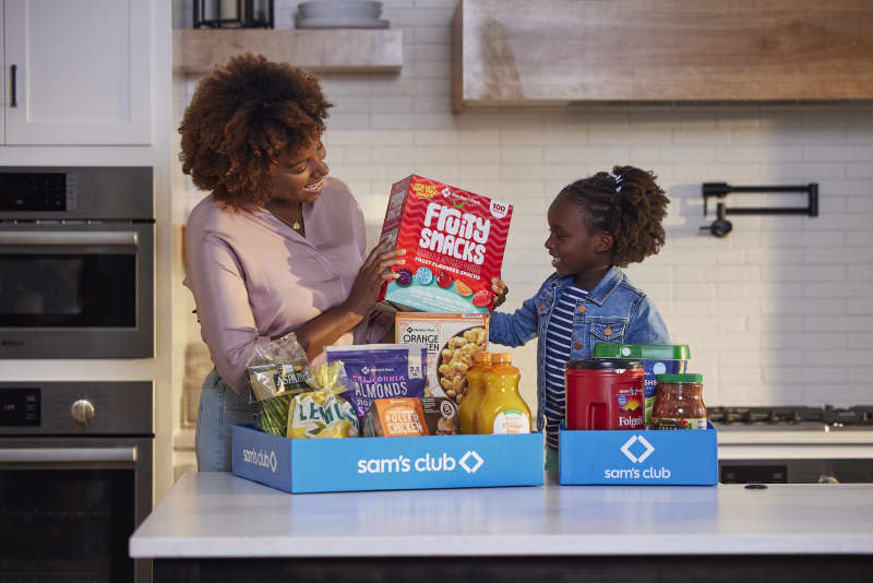 Mother and daughter with Sam's Club delivery boxes on counter