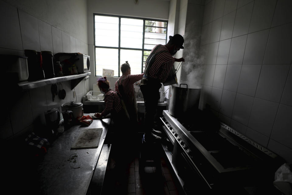 Los miembros del grupo "Circo Encuentro" preparan una sopa con alimentos donados que recolectaron en Bogotá, Colombia, el sábado 4 de julio de 2020. El grupo creado hace 11 años se dedica ahora a intercambiar su show por alimentos para ayudar a personas en los barrios más pobres al sur de la capital colombiana en medio de la crisis sanitaria por el nuevo coronavirus. (Foto AP/Fernando Vergara)