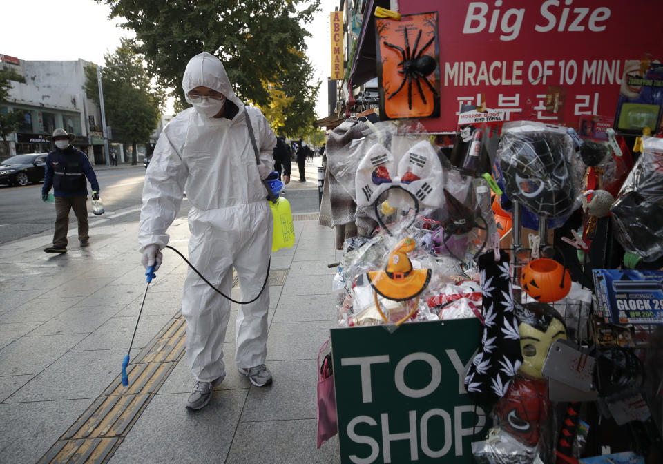 A man wearing protective gear disinfects on a street as a precaution against the coronavirus in Seoul, South Korea, Thursday, Oct. 29, 2020. (AP Photo/Lee Jin-man)