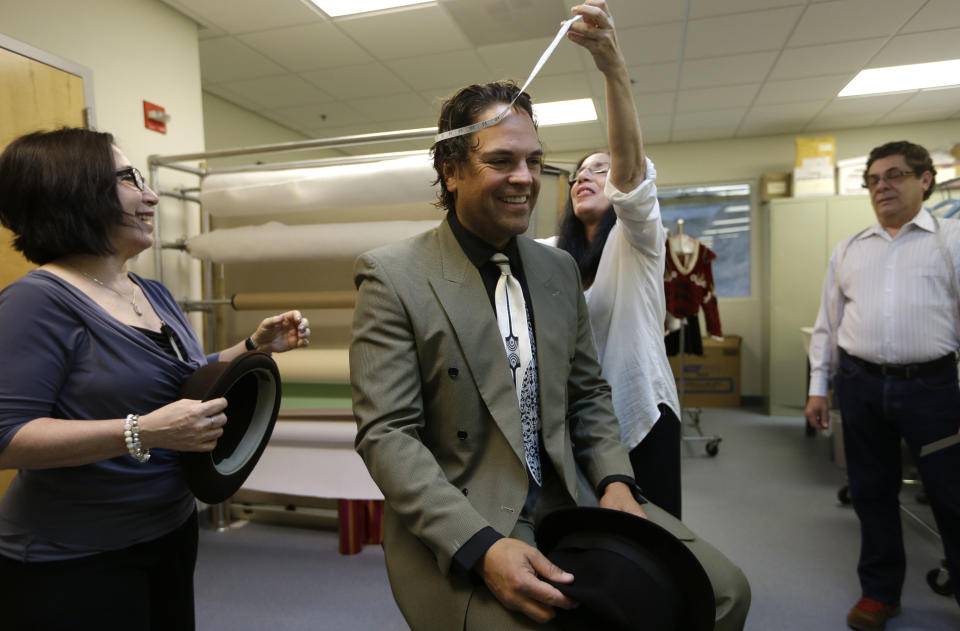 Former MLB baseball player Mike Piazza is fitted for his costume by Maria Morales for his role in "Slaughter on Tenth Avenue" at the Miami City Ballet, as costume designer Haydee Morales, looks on at left, Tuesday, April 16, 2013, in Miami Beach, Fla. Piazza will play a gangster in the ballet on May 3. He will say a few lines and then watch the rest of the performance from a seat onstage. Piazza says his turn with the troupe is his gift to his 6-year-old daughter, a student at Miami City Ballet School. (AP Photo/Lynne Sladky)