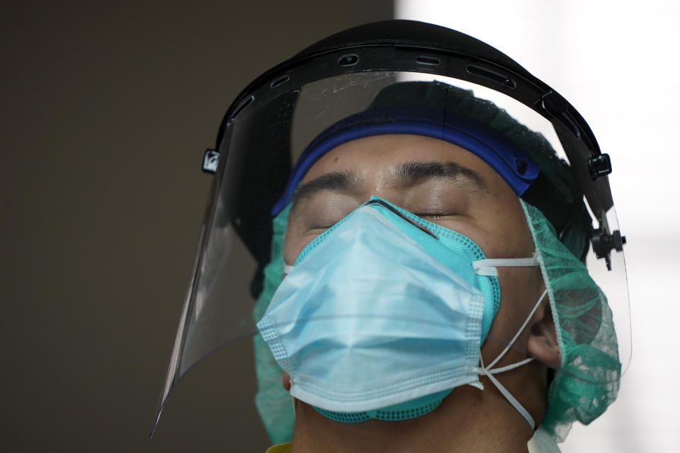 Medical student Diego Montelongo closes his eyes briefly as he watches others attempt to save the life of a patient inside the Coronavirus Unit at United Memorial Medical Center, Monday, July 6, 2020, in Houston. Despite all their efforts, the patient died. (AP Photo/David J. Phillip)