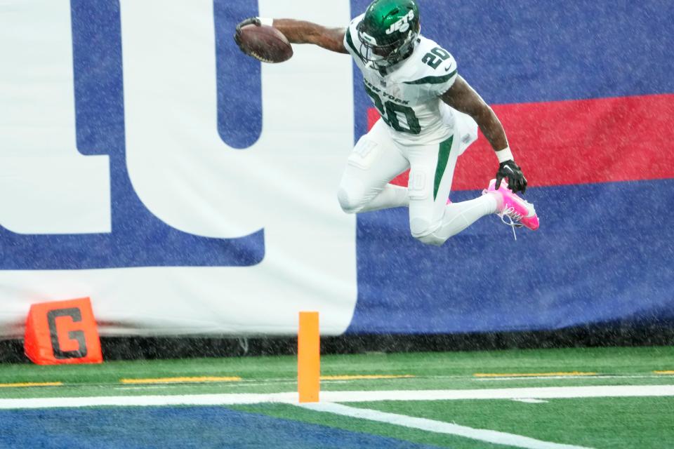 October 29, 2023; East Rutherford, NJ, USA; New York Jets running back Breece Hall (20) leaps over the goal line for the only touchdown of the first half.