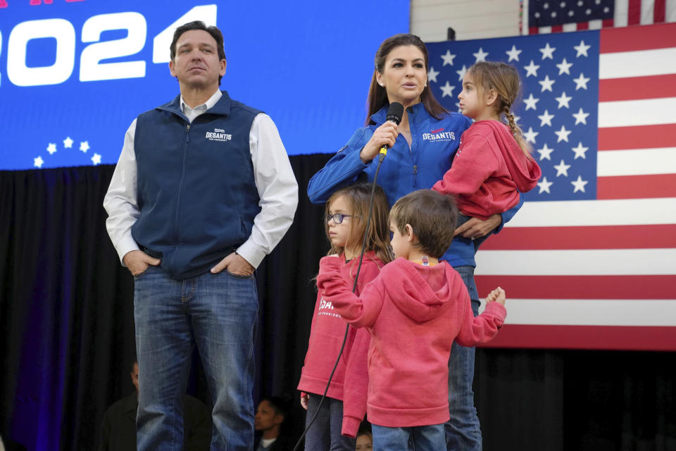 Republican presidential candidate Florida Gov. Ron DeSantis, left, looks on as his wife Casey DeSantis, carrying daughter Mamie, speaks during a campaign event at The Hangout on Saturday, Jan. 20, 2024, in Myrtle Beach, S.C. Standing in foreground are DeSantis' children Madison, left, and Mason. (AP Photo/Meg Kinnard)