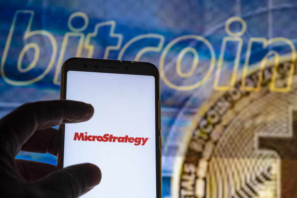 SPAIN - 2021/12/09: In this photo illustration the MicroStrategy logo is seen on the screen of a smartphone with a bitcoin cryptocurrency logo in the background. (Photo Illustration by Paco Freire/SOPA Images/LightRocket via Getty Images)