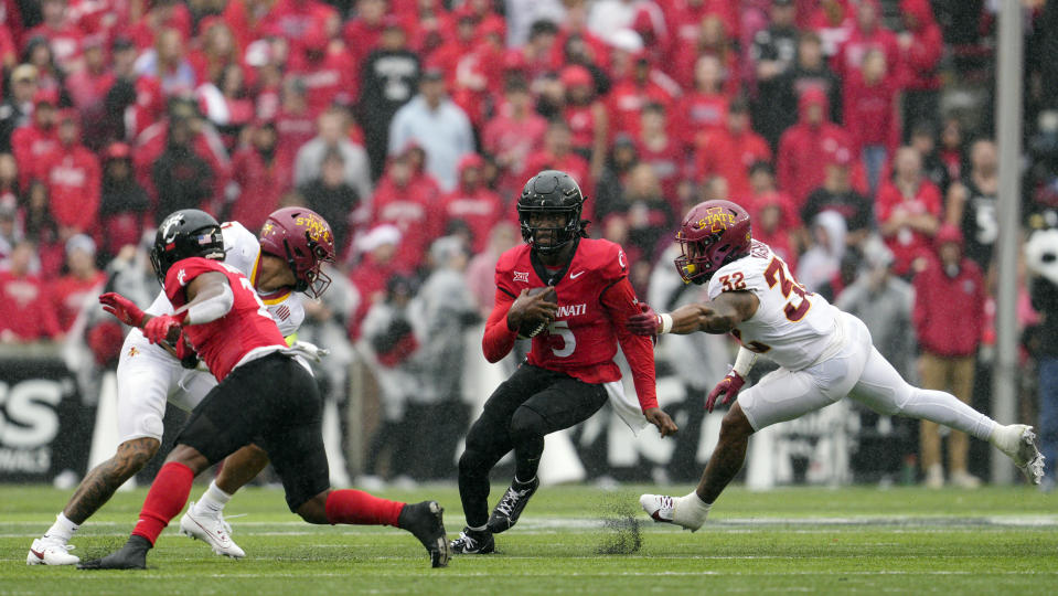 Cincinnati quarterback Emory Jones (5) breaks a tackle by Iowa State linebacker Gerry Vaughn (32) during the second half of an NCAA college football game, Saturday, Oct. 14, 2023, in Cincinnati. (AP Photo/Jeff Dean)