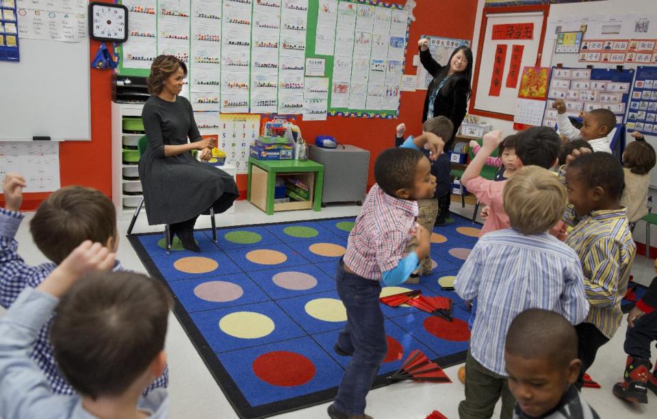 First lady Michelle Obama sways her hands in a move from the South Korean song "Gangnam Style," as pre-Kindergarten teacher Crystal Chen, right, leads a class in a surprise rendition of "Gangnam Style", during a visit from the first lady to the Yu Ying Public Charter School in Washington, Tuesday, March 4, 2014. The pre-Kindergartners also performed a fan dance and had a Mandarin lesson. The first lady is expected to take a trip to China along with her daughters and mother later in March. (AP Photo/Jacquelyn Martin)