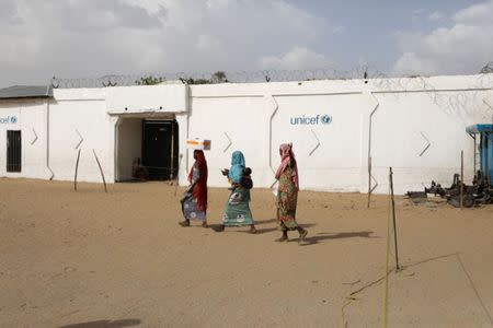 A woman, followed by two other women, carries a box of food supplement provided to them by the World Food Programme (WFP) at the Banki IDP camp, Borno, Nigeria April 26, 2017. REUTERS/Afolabi Sotunde