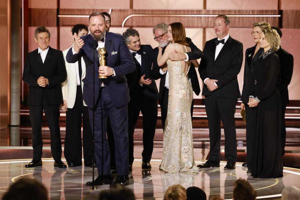 This image released by CBS shows filmmaker Yorgos Lanthimos, foreground, with the cast as he accepts the award for best motion picture - musical or comedy for "Poor Things" during the 81st Annual Golden Globe Awards in Beverly Hills, Calif., on Sunday, Jan. 7, 2024. (Sonja Flemming/CBS via AP)