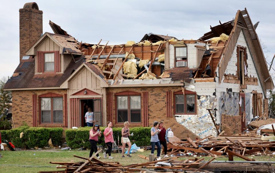 Residents continue to recover possessions and secure homes that were damaged by Friday's tornado - Scott Olson/Getty Images