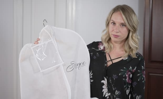 Jillian Wilson's wedding dress is still in a garment bag since her destination wedding was cancelled more than a year ago as COVID-19 brought international air travel to a halt. Wilson says she wants the roughly $70,000 her group spent on Sunwing airfare to be refunded.   (Turgut Yeter/CBC News - image credit)