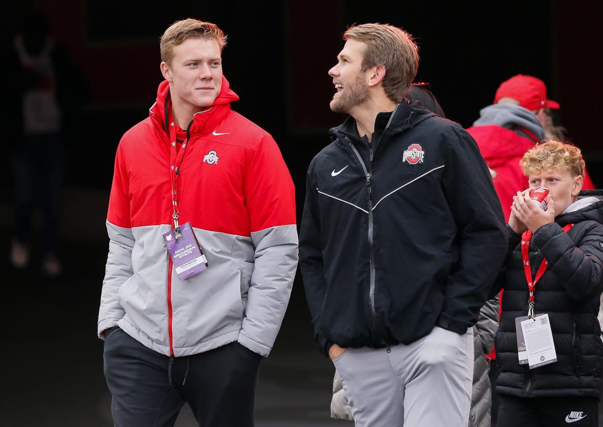 Football recruit Devin Brown, a quarterback from Corner Canyon High School in Utah, walks onto the field with Ohio State Buckeyes quarterbacks coach Corey Dennis prior to the game against the Michigan State Spartans at Ohio Stadium in Columbus on Saturday, Nov. 20, 2021. 